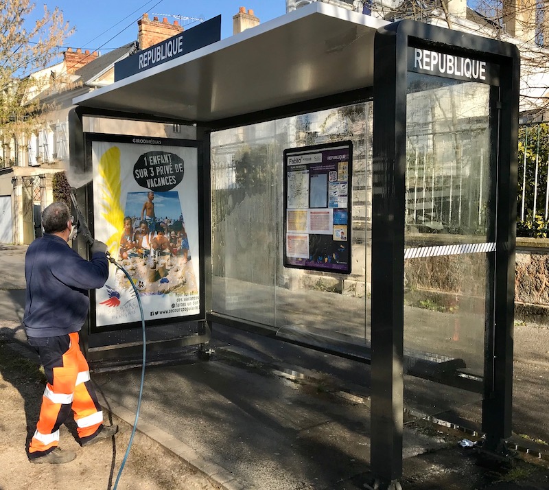 Homme en train de nettoyager l'abri bus à Château-Thierry
